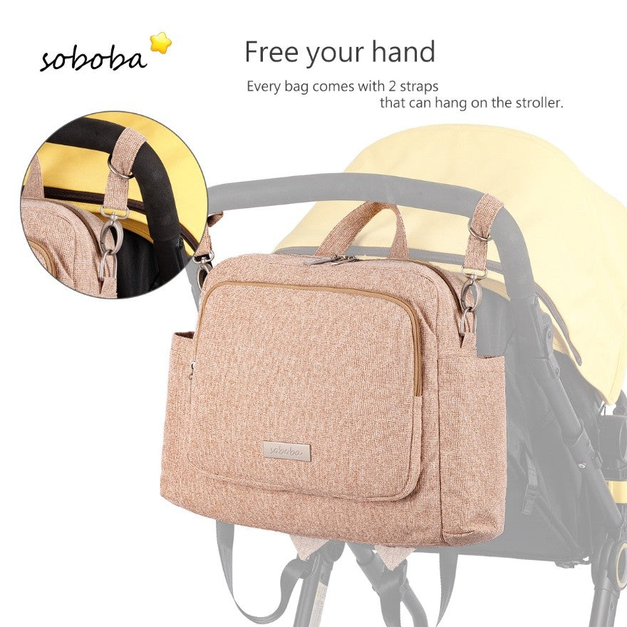 Sandybrown diaper bag backpack hanging on stroller with two straps for hands-free use
