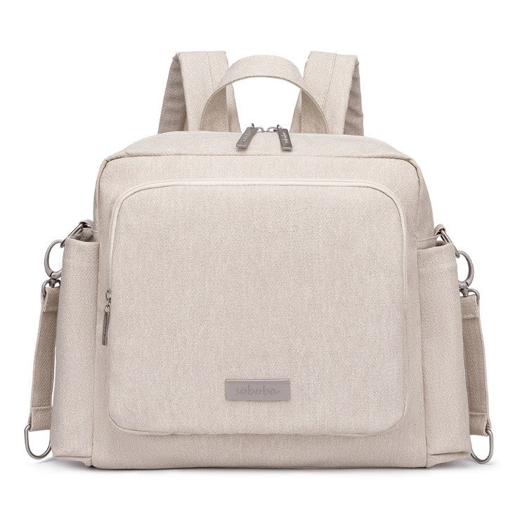 Beige vegan leather diaper bag backpack with multiple compartments and adjustable straps