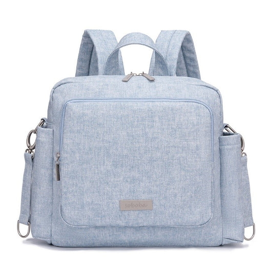 Light blue vegan leather diaper bag backpack with multiple pockets and adjustable straps
